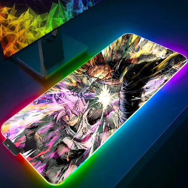 Un tappetino per mouse da gaming RGB con una stampa che raffigura Goku Black con i capelli rosa e Super Saiyan God Vegeta con i capelli blu intenti in una battaglia. I bordi del tappetino sono illuminati da una luce arcobaleno.