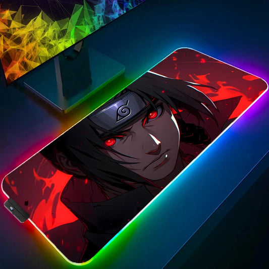 Un tappetino per mouse da gaming RGB con un'illustrazione del personaggio di Naruto, Itachi Uchiha. L'immagine mostra un primo piano del personaggio con i capelli scuri e gli occhi rossi e luminosi, con uno sfondo rosso intenso. I bordi del tappetino sono illuminati da una luce RGB.