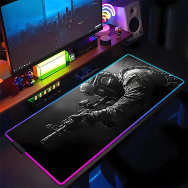  Deskpad gaming XXL con illuminazione RGB e immagine di un soldato in azione in una scena di battaglia notturna.